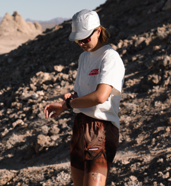 Female runner reviewing data on Suunto watch in desert